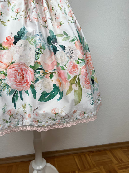 Detailansicht von Bordürendruck mit großen Blumen in creme und rosa und grünen Blättern, rosa Spitze am Saum