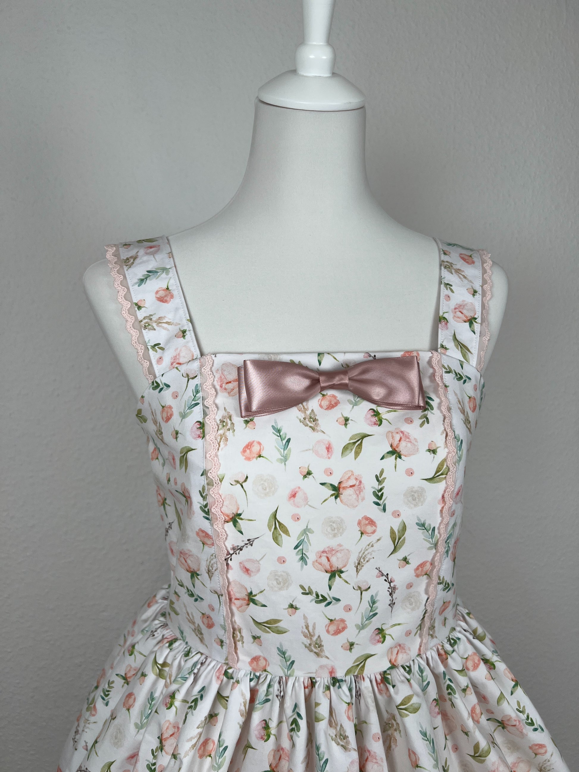 Detailansicht Vorderteil, rosa Schleifenbrosche aus Satinband, rosa Spitze an Teilungsnaht Vorderteil und Trägern