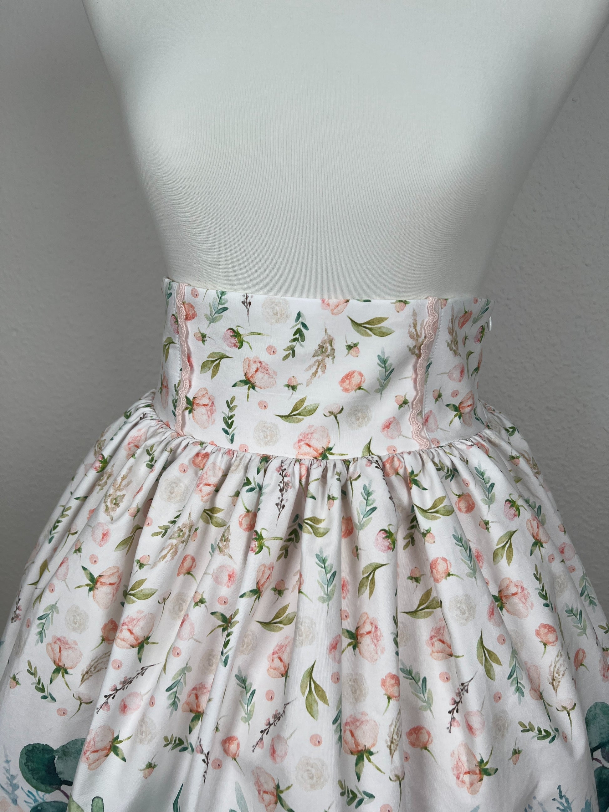 High Waist Bund mit rosa Spitze, gekräuseltes Rockteil, weißer Stoff mit rosa Blumen und grünen Blättern