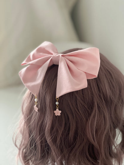 rosafarbene Haarschleife mit Kirschblütenanhängern an Perückenkopf