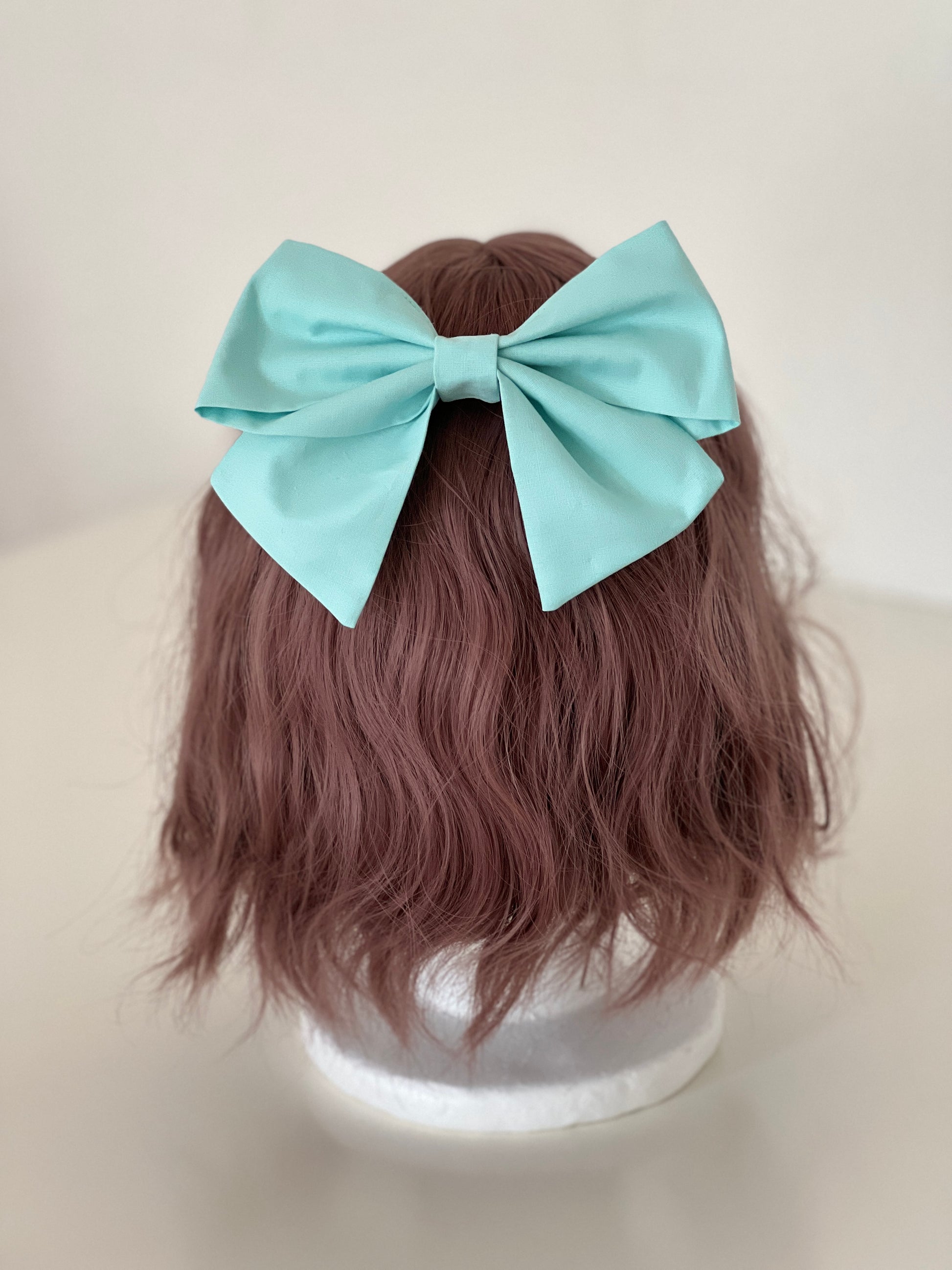 mintfarbene Haarschleife auf Perückenkopf
