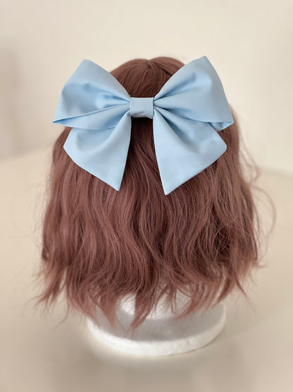 hellblaue Haarschleife auf Perückenkopf
