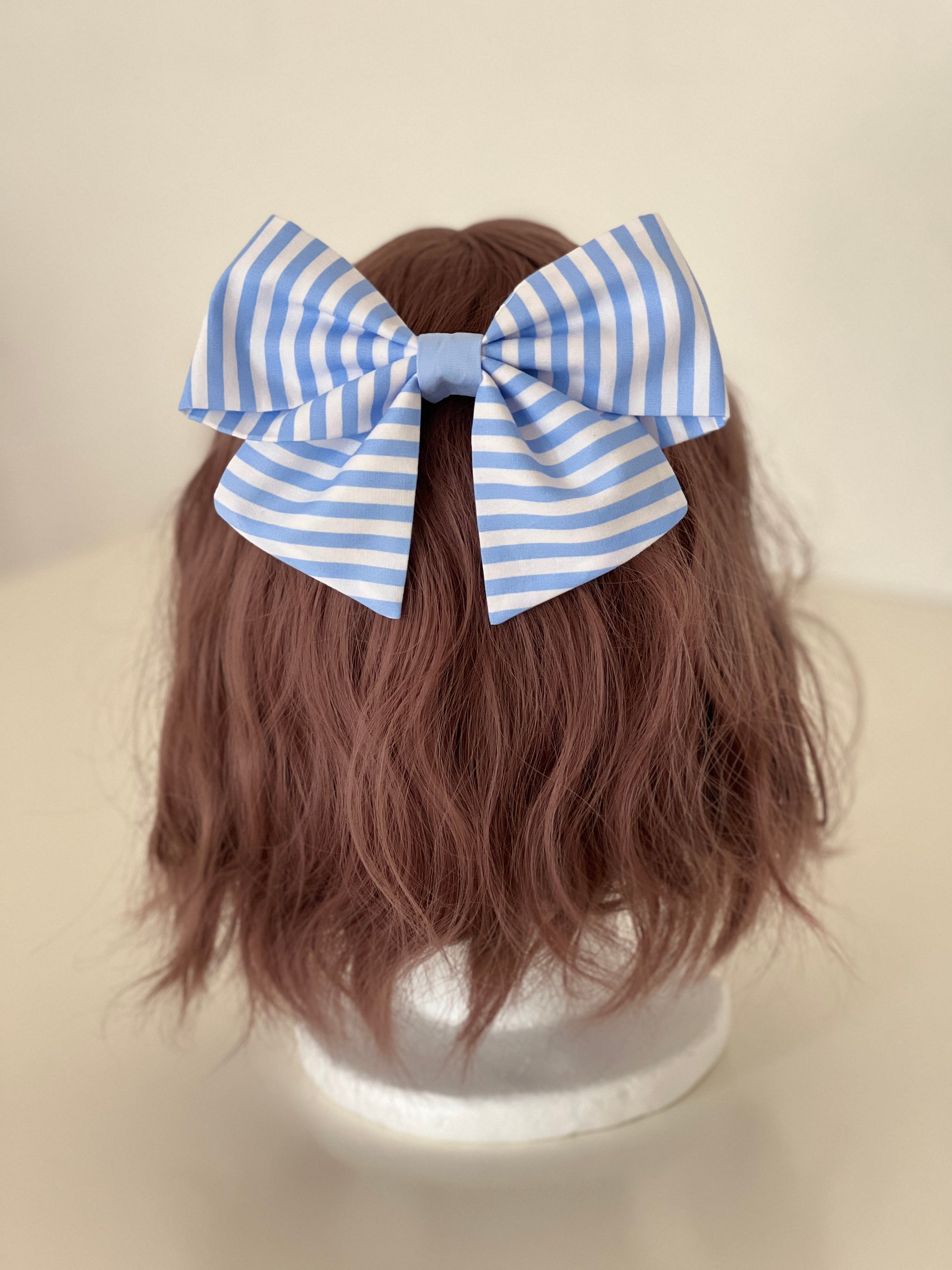 gestreifte Haarschleife in hellblau und weiß auf Perückenkopf