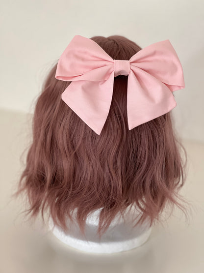 rosafarbene Haarschleife an Perückenkopf