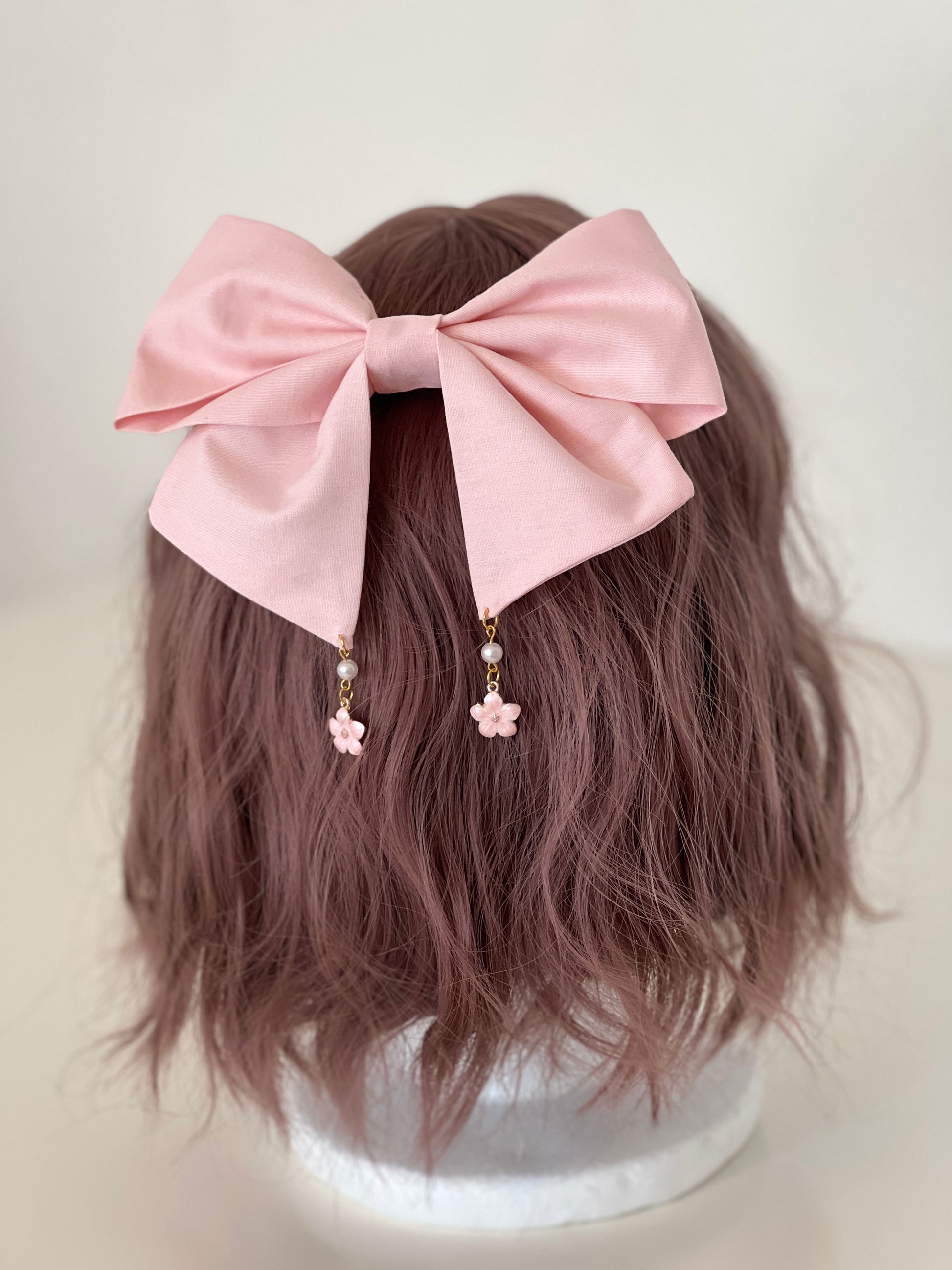 rosafarbene Haarschleife mit kleinen Anhängern in Kirschblütenform