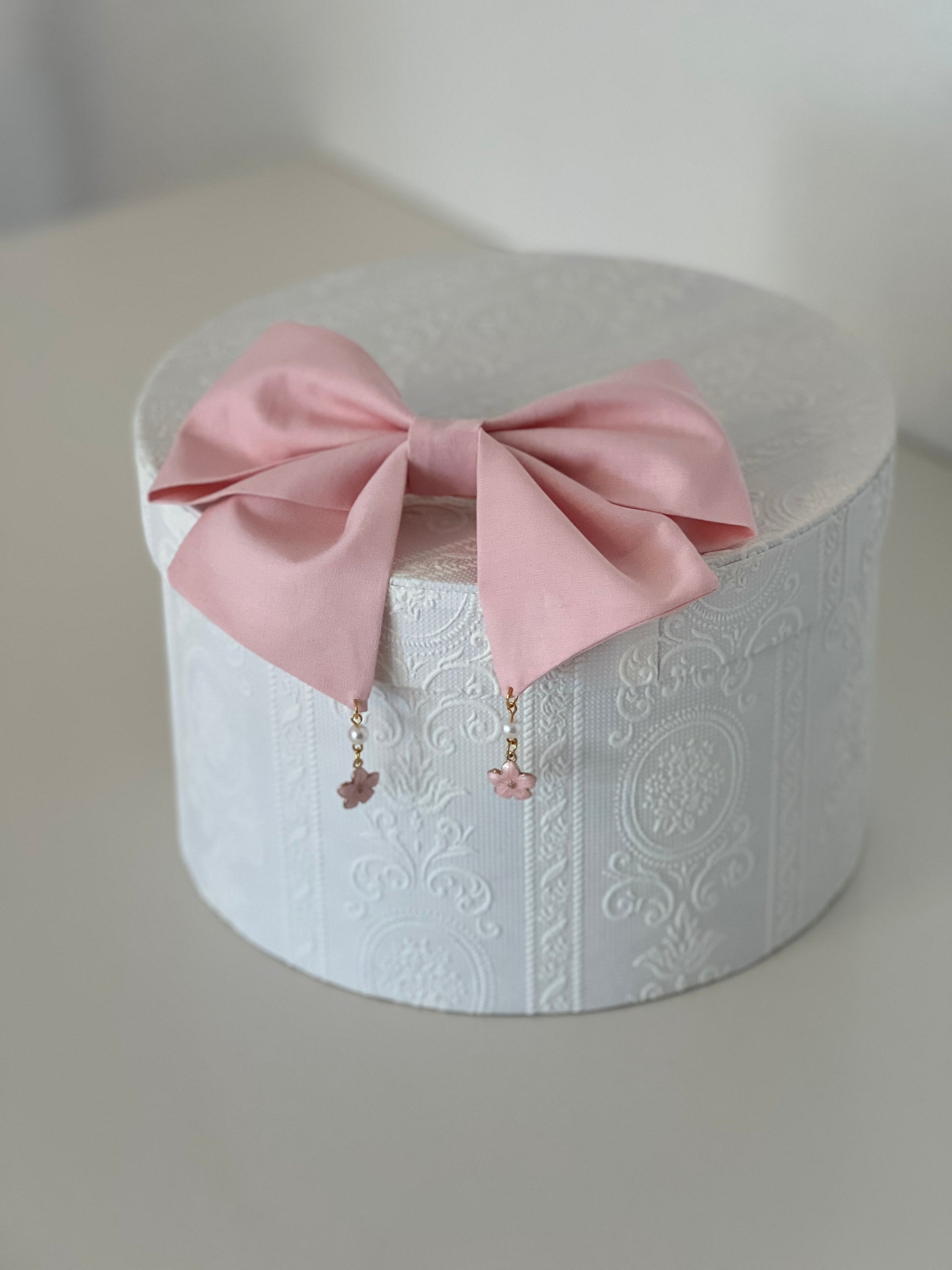 rosafarbene Haarschleife mit Kirschblütenanhängern, flach liegend