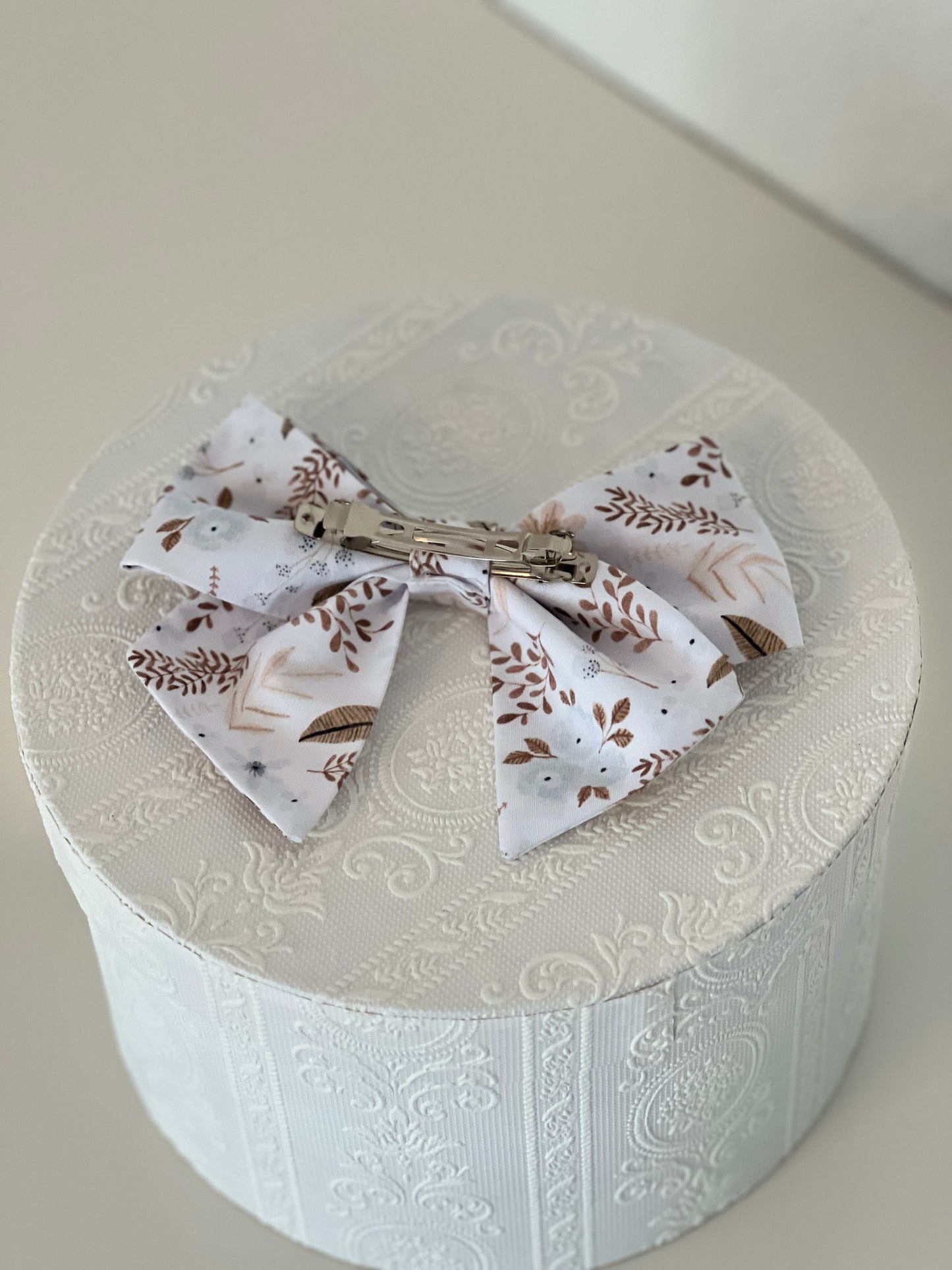 Rückseite Haarschleife mit Streublumen in hellblau und Brauntönen, silberfarbene Haarspange