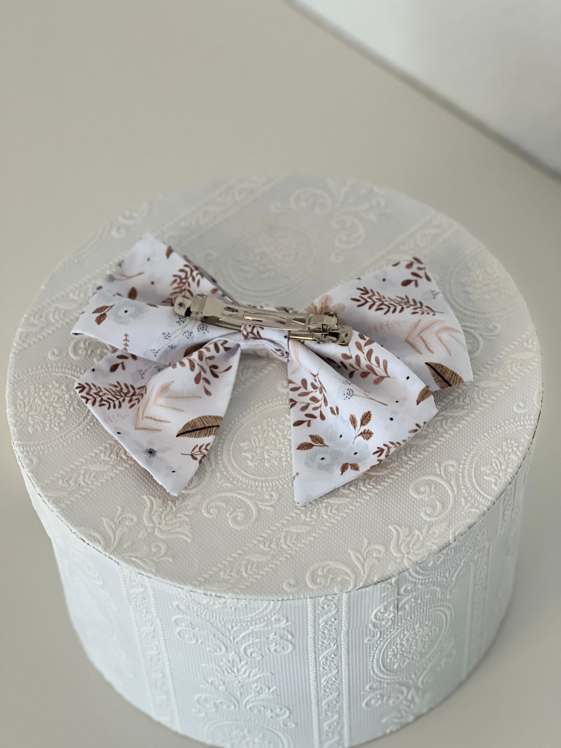 Rückseite Haarschleife mit Streublumen in hellblau und Brauntönen, silberfarbene Haarspange