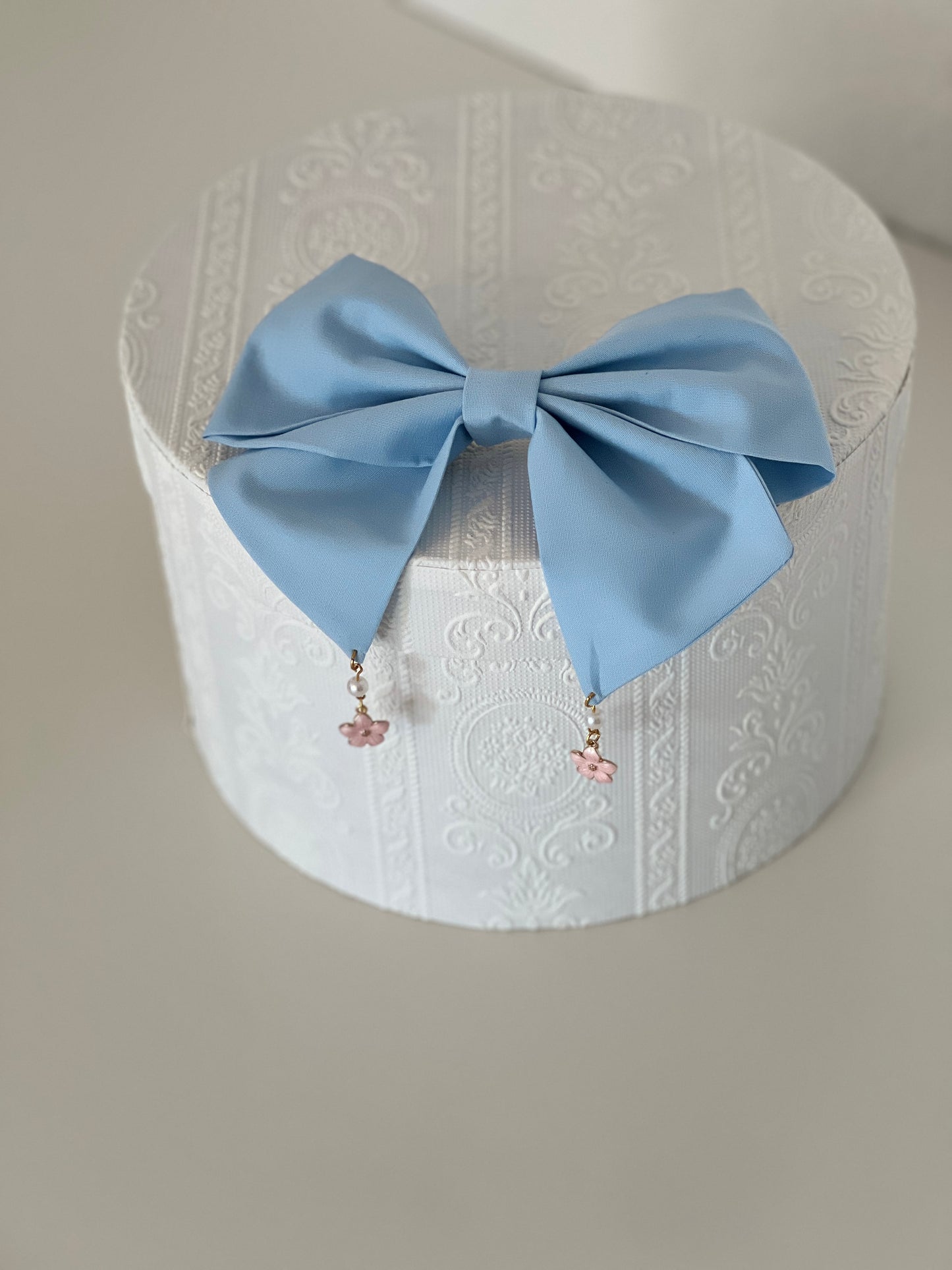 hellblaue Haarschleife mit Anhängern in Kirschblütenform, flach liegend